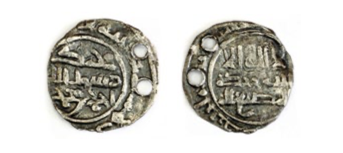 Une pièce d'argent islamique (dirham) du Xème siècle retrouvée en Bulgarie volgaïque avec deux trous qui indiquent son utilisation comme pendentif (conservée au Bolgar State Historical and Architectural Reserve)